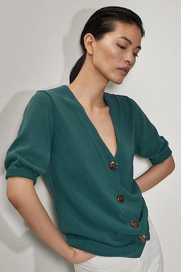 En color verde y con manga corta abullonada, este cardigan en uno de los más deseados de la colección.