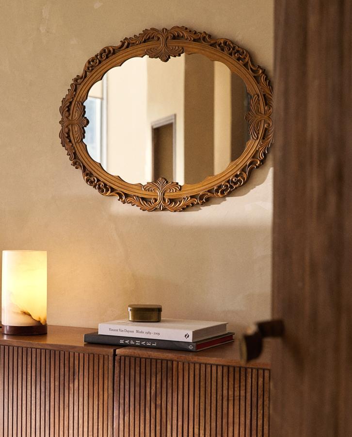En formato ovalado, este espejo de pared con perfil de madera labrada en forma de detalles ornamentales tiene un precio de 79,99 euros.