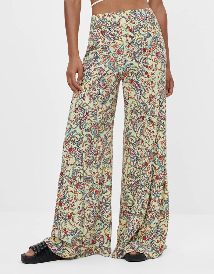 Estampado paisley en tonos azules y rojos para este pantalón de Bershka en amarillo pastel con pernera ancha y cintura elástica en la espalda. De 29,99 euros ha pasado a costar 15,99 euros y está disponible entre las tallas XS y L.