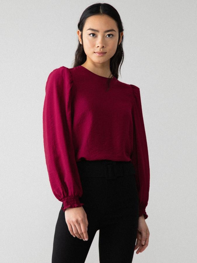 De cuello redondo y manga larga abullonada acabada en goma, esta blusa en burdeos costaba 9,99 euros y ahora podemos encontrarla por 5,99 euros únicamente en la talla XS.