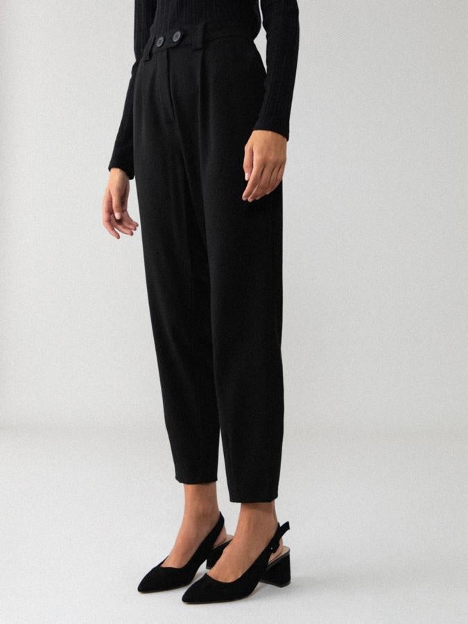 En diseño jogger con pinzas y goma en la cintura, este pantalón negro con bolsillos laterales y detalle de botones en la cintura está disponible entre las tallas S y XXL por 9,99 euros (antes 15,99 euros).