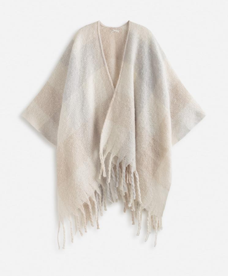 En color crudo con estampado de cuadros, este amoroso poncho con detalle de flecos tiene ahora un precio de 25,99 euros.
