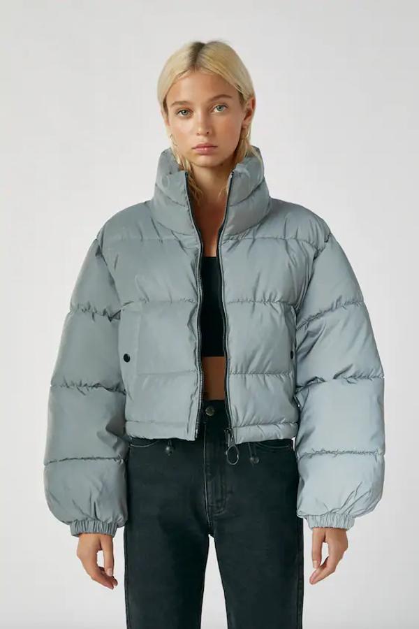 En tejido reflectante en color gris, esta cazadora acolchada de Pull&Bear con cuello alto, bolsillos laterales y cierre frontal de cremallera tenía un precio de 35,99 euros y ahora está por 29,99 euros en las tallas XS y L.