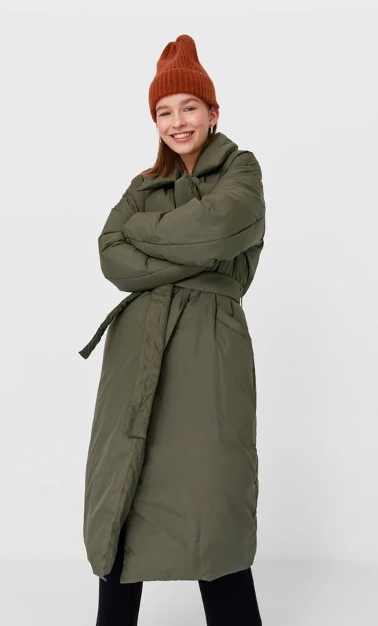 Este abrigo trench de cuello y solapa con detalle de cinturón a tono en color caqui es de Stradivarius y de 49,99 euros ha pasado a costar 39,99 euros y está disponible en las tallas M y L.