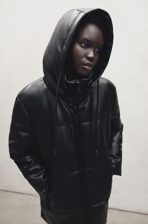 En color negro, con cuello subido y capucha ajustable con cordón, este abrigo acolchado de Zara en efecto piel viene con bolsillos delanteros y detalle de aberturas laterales con cremallera. Con cierre frontal con cremallera, cuesta 79,95 euros y está disponible entre las tallas XS y XXL.