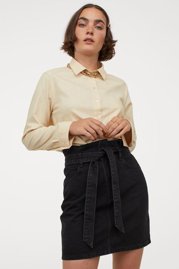 En beige claro, esta camisa de corte recto confeccionada en tejido de algodón, con cuello, tapeta de botones, bolsillo superior abierto y mangas largas con puños sencillos. Con bajo redondeado asimétrico, ha pasado de 14,99 euros a 5,99 y está disponible entre las tallas XS y L.