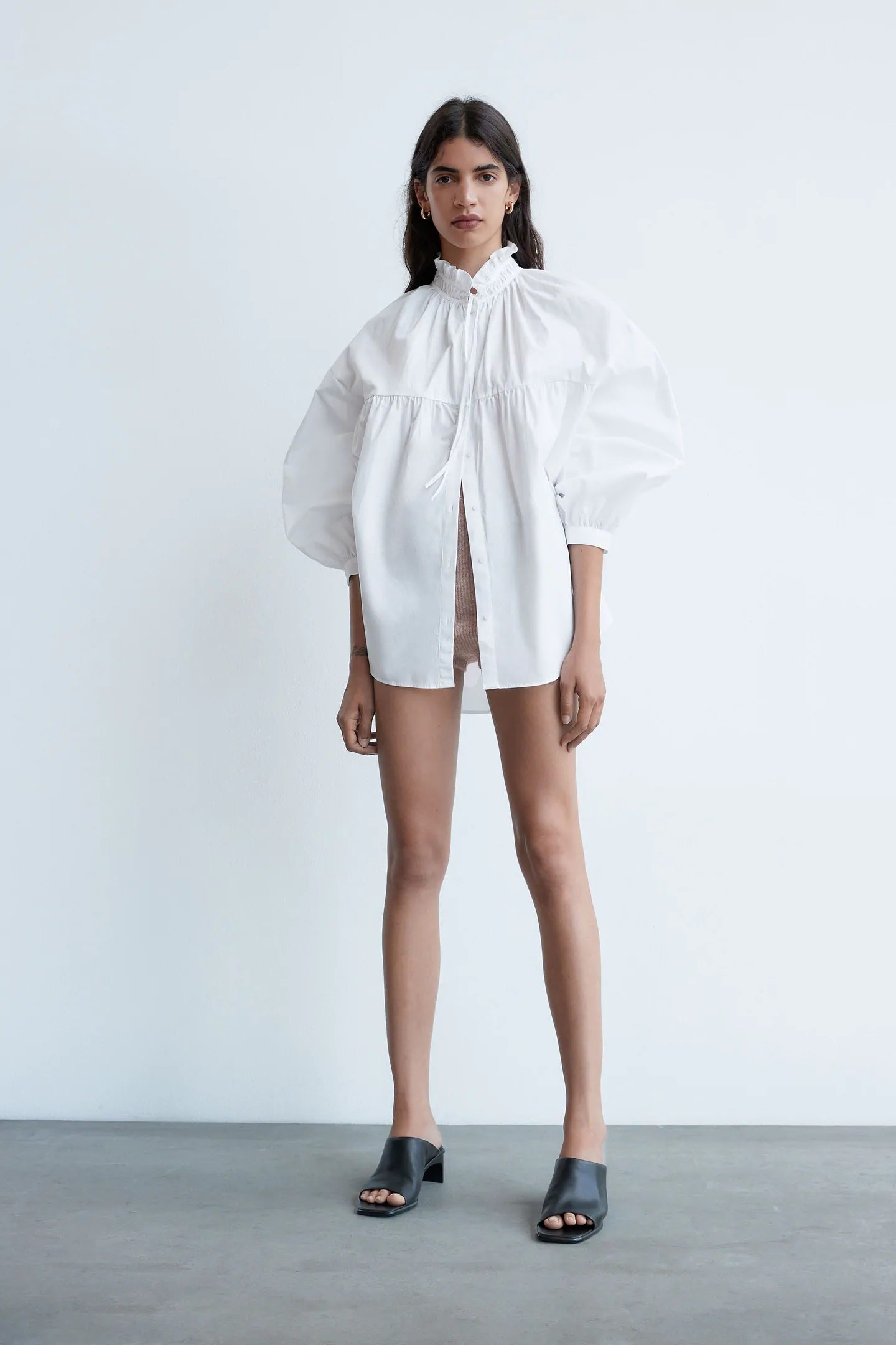 Camisa blanca popelín con manga amplia y cuello subido con lazada. Una prenda romántica de Zara que suma mucho estilo. Rebajada a 15,99 euros.