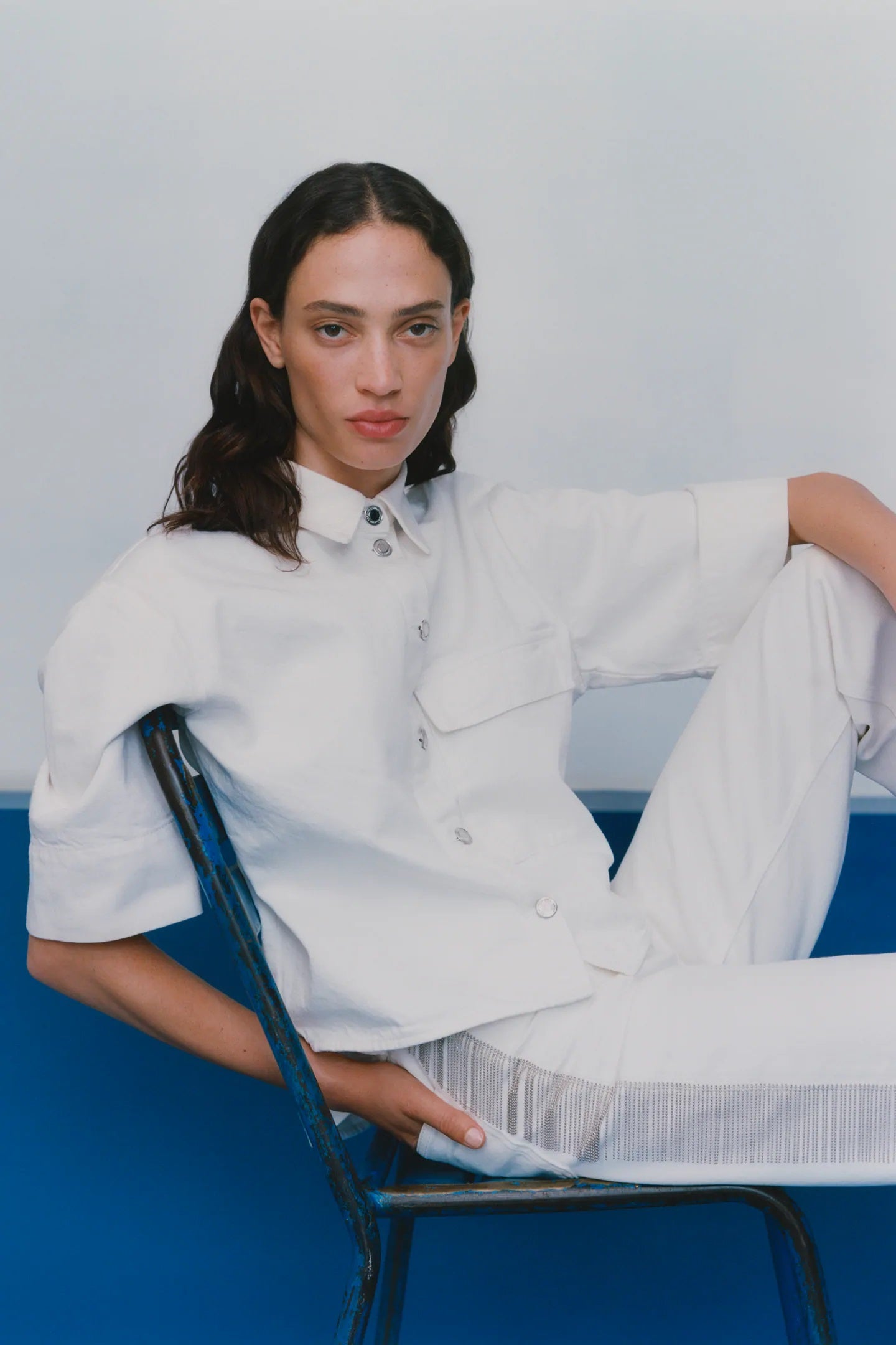 Camisa blanca cropped de manga corta y botones metálicos. (15,99 euros).