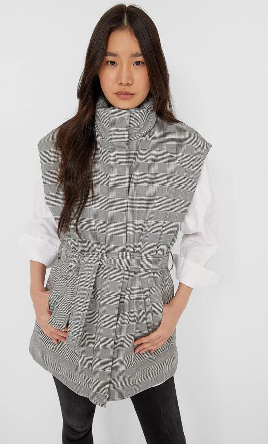 La propuesta más estilosa de esta selección es este chaleco padding de Stradivarius con estampado de cuadros en negro, blanco y gris. Con cuello subido, cierre frontal de cremallera oculto y cinturón a tono, está rebajado y de 35,99 euros a 19,99 euros y podemos encontrarlo en las tallas S y M.