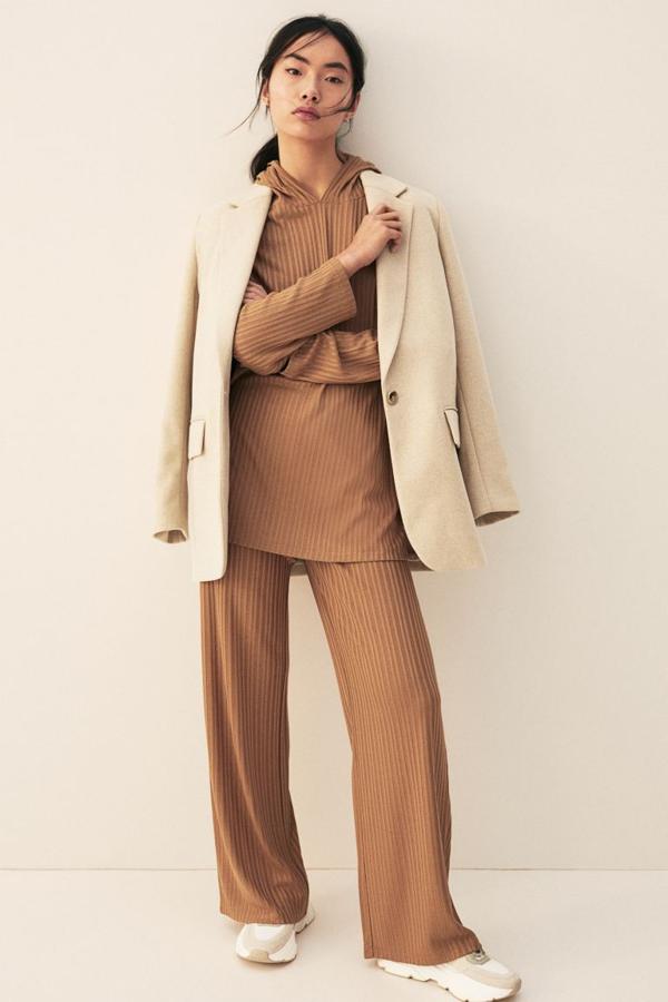 Disponible en beige oscuro, crudo y negro, este pantalón en punto de canalé de mezcla de viscosa y poliéster reciclado viene con diseño de talle alto con elástico revestido en la cintura y perneras amplias rectas. Podemos encontrarlo entre las tallas XS y XXL por 9,99 euros.