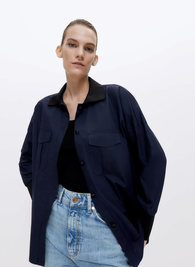 Esta camisa combinada de punto en negro y azul marino está confeccionada en tejido de popelín combinado con tejido de circular en el mismo tono y viene con cuello clásico y abertura mediante tapeta frontal con botones de piel, puños y cuello de tejido circular de punto y bolsillos a ambos lados con tapeta. En diseño oversize, costaba 59 euros y está disponible ahora pode 39,95 euros en las tallas S y M.