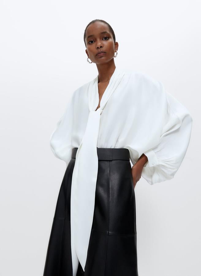 En color crudo, con cuello de lazada larga, volumen amplio y manga abullonada acabada en puño, esta camisa de escote de pico botones forrados costaba 89 euros y ahora está disponible por 59,95 euros en las tallas S y M.