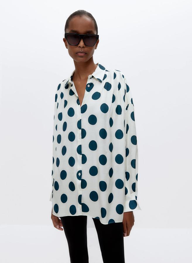 Confeccionada en tejido satinado estampado, esta camisa blanca con topos en color verde tiene cuello clásico, abertura mediante tapeta frontal y detalle de pliegues en el hombro. Solo queda en la talla M y de 79 euros ha pasado a 49,95 euros.