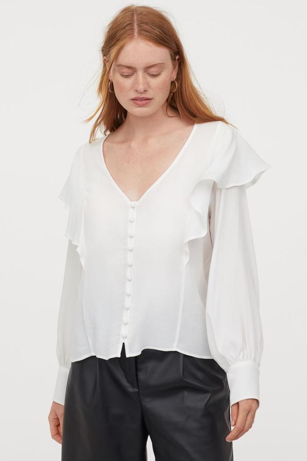 Blusa blanca de corte recto con escote de pico y volantes. Rebajada de 19,99 a 5,99 euros.