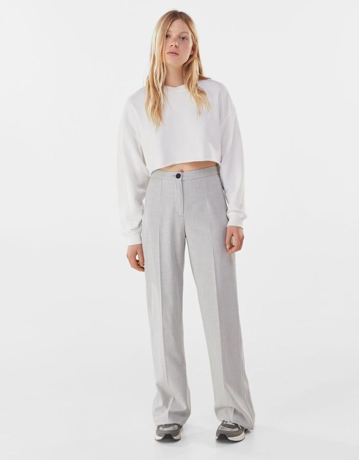 Pantalón de pernera ancha en color gris claro de Bershka: 22,99 euros. Disponible de la talla 32 a la 44.