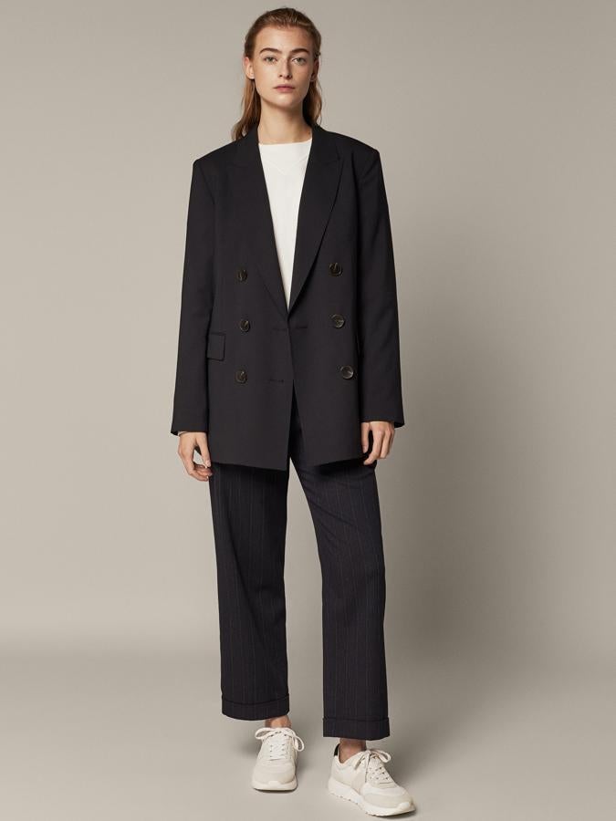 En azul marino, confeccionada en lana y con cierre cruzado de doble botonadura, esta americana de Massimo Dutti viene con cuello con solapa de pico, dos bolsillos con solapa, puños abotonados y abertura en la parte posterior. Con un precio de 149 euros, podemos encontrarla entre las tallas 34 y 44.