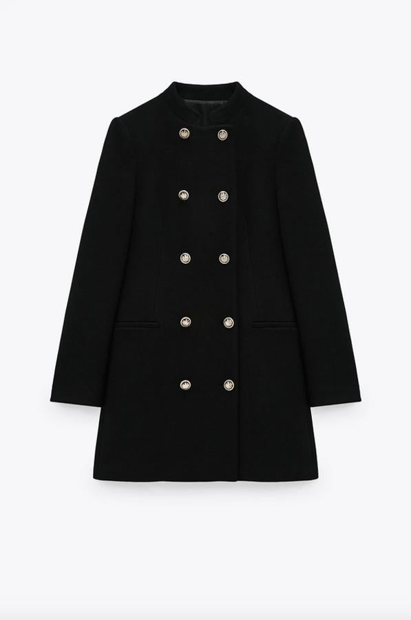 Confeccionada en tejido con mezcla de lana, esta blazer de Zara en color negro viene con cuello subido, bolsillos laterales de vivo y cierre frontal cruzado con botones metálicos. Cuesta 59,95 euros y está disponible entre las tallas XS y XL.