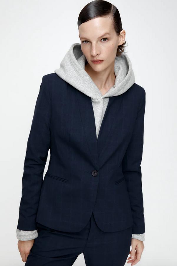 Esta blazer de solapa invertida y estampado ligero de cuadros sobre el azul marino es de Zara y viene con hombros marcados, bolsillos delanteros de doble vivo y bajo con abertura en la espalda. Podemos encontrarla entre las tallas 34 y 46 por 29,95 euros.