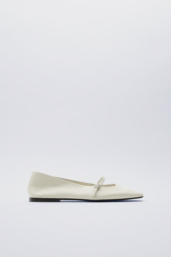 Merceditas de piel blanca con tira cerrada por una hebilla, de Zara (9,99 €).