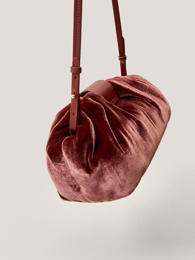 Este bolso tipo pouch en terciopelo está disponible en cobre rosa y en negro y viene con correa de hombro ajustable a tono y un único compartimento principal. De 79,95 euros ha pasado a costar 35,95 euros.