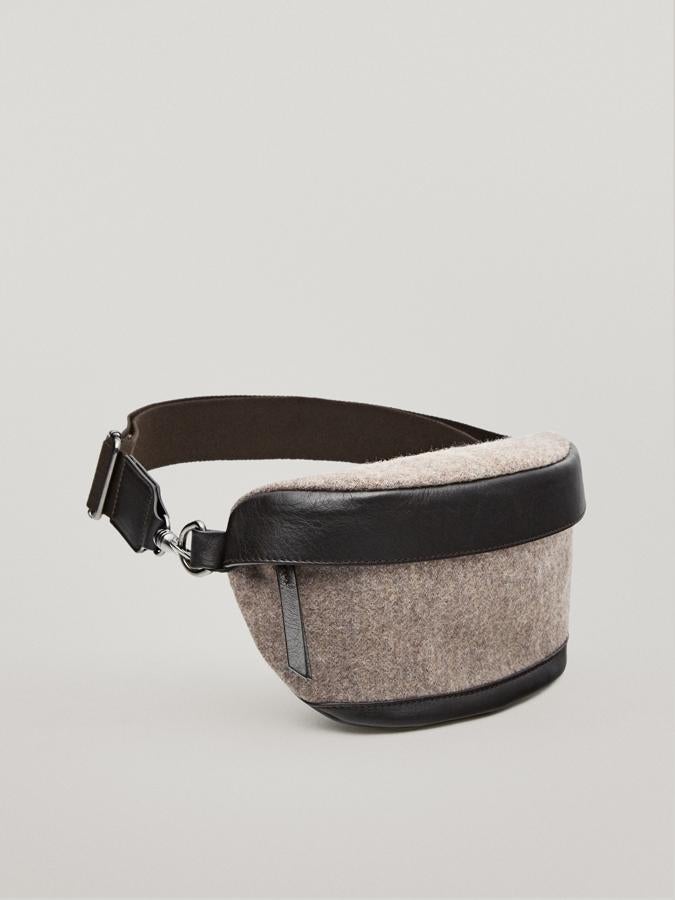 Con cuerpo en color beige y correa y bajo en marrón, esta riñonera de lana y piel con cierre de cremallera y correa ajustable costaba 69,95 euros y ahora podemos encontrarla por 35,95 euros.