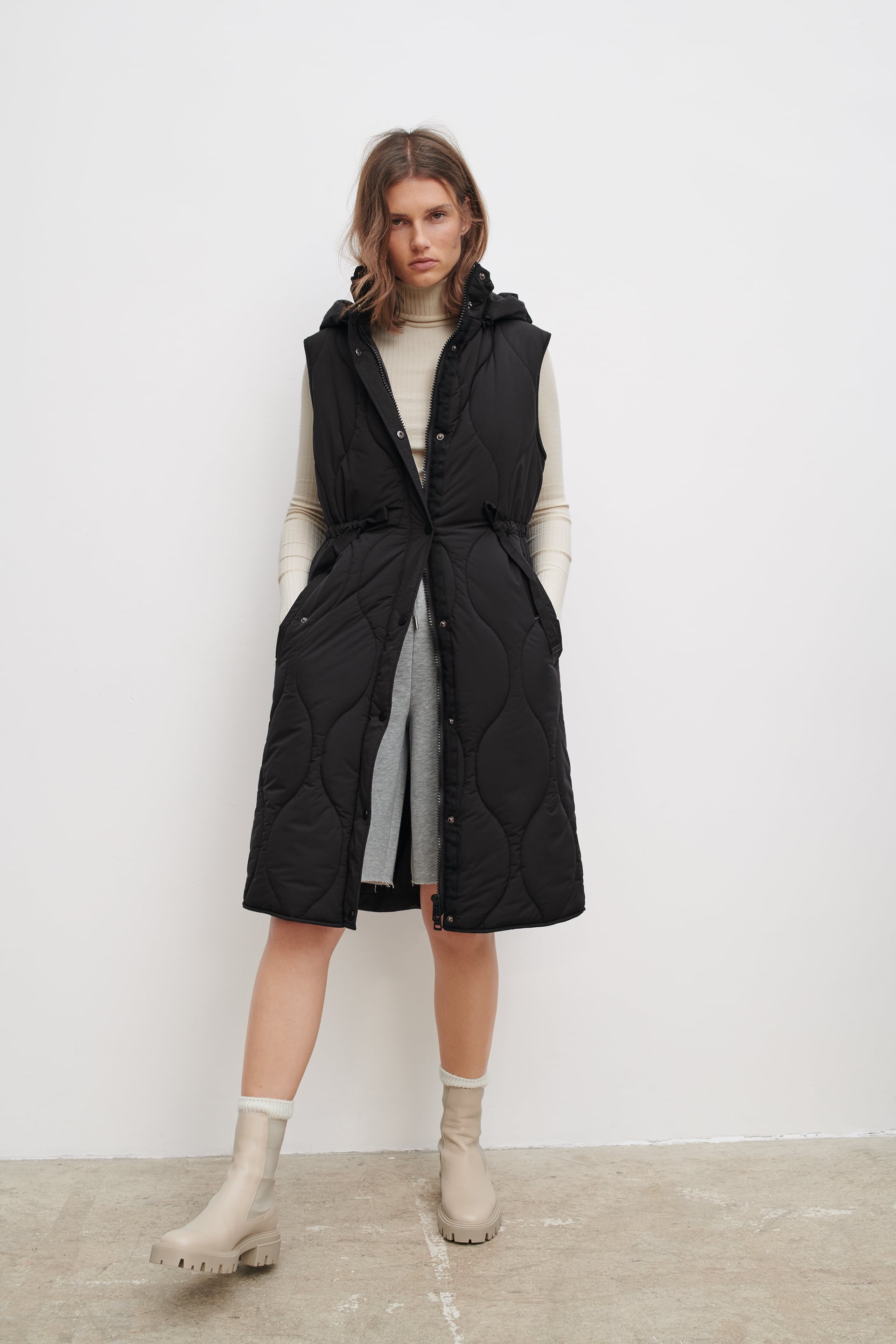 Chaleco acolchado negro con cinturón y capucha de la nueva colección de Zara (49,99 euros)