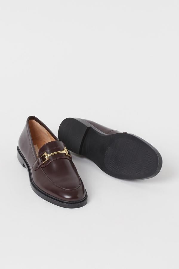 En color burdeos con detalle dorado en el empeine, estos mocasines de piel de H&M tienen un precio de 59,99 euros y están disponibles entre los números 35 y 42.