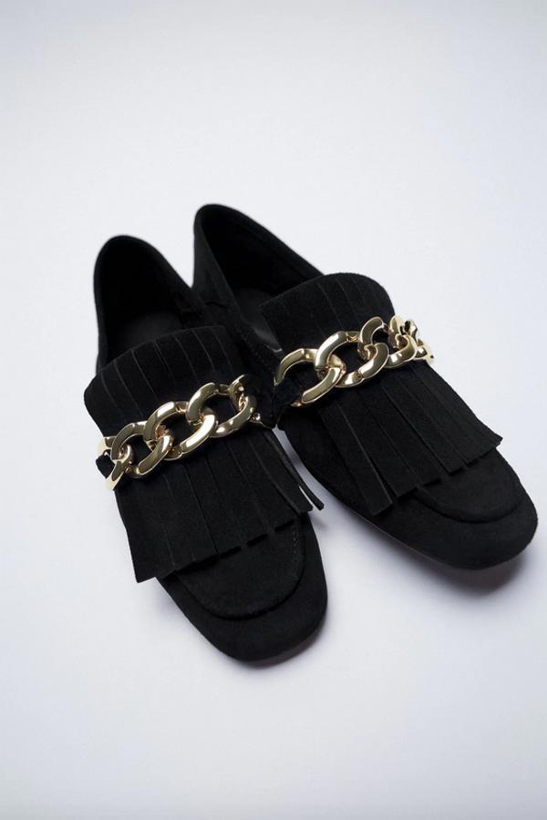 Estos mocasines en serraje con corte de piel con detalle de flecos y cadena en el empeine en color negro son de Zara y vienen con la punta cuadrada. Disponibles entre los números 35 y 42, cuestan 39,95 euros.