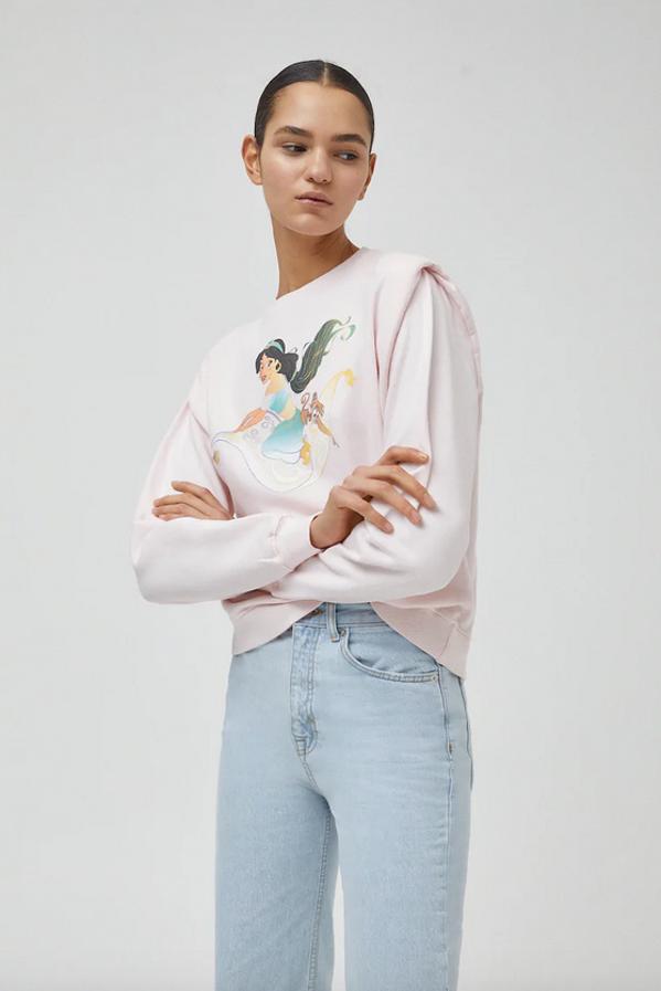 En Pull&Bear hemos encontrado esta sudadera en color rosa con ilustración frontal de Jasmine, mangas largas con hombreras y cuello redondo confeccionada con al menos un 65% de algodón orgánico. Disponible entre las tallas XS y L, cuesta 22,99 euros.