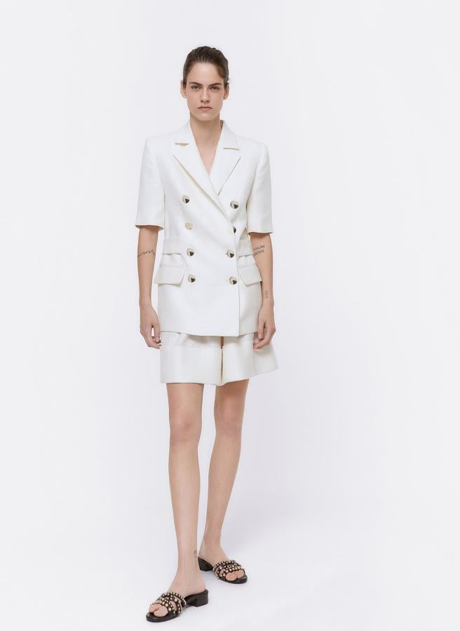 Derrocha estilo retro, elegancia y estilazo con este traje blanco de chaqueta de manga corta (rebajada a 69.90 euros en Uterqüe) y bermudas a juego (rebajadas a 39.90 euros).