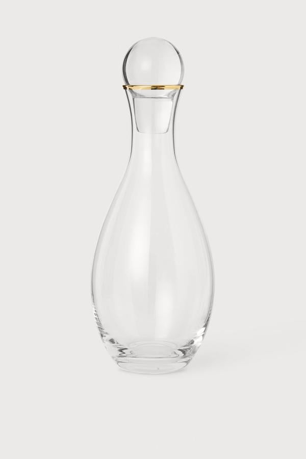 Esta jarra de vidrio transparente con borde dorado y tapón redondo cuenta con una altura aproximada de 30 centímetros y tiene un precio de 14,99 euros.