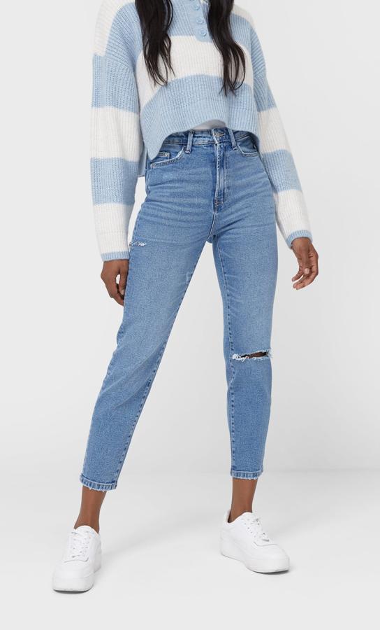 Con pierna relajada y cintura alta, estos vaqueros en denim claro de Stradivarius con roto en la rodilla y bajos tobilleros cuestan 19,99 euros y están disponibles entre las tallas 32 y 44.