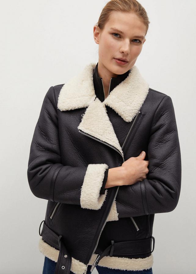 Con cuello, puños y bajo en pelo sintético, esta cazadora negra de diseño estructurado en formato midi con solapas, bolsillos laterales, costuras y cinturón decorativos y cierre diagonal de cremallera metalizada tiene un precio de 79,99 euros y está disponible entre las tallas XS y XL.