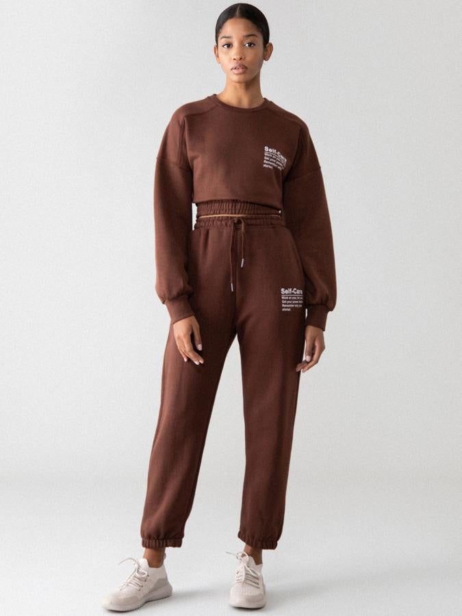 En marrón chocolate, con diseño cropped y cintura elástica, esta sudadera de Lefties con estampado de texto a contraste en blanco está confeccionada en tejido suave y elástico y podemos encontrarla entre las tallas S y XL por 9,99 euros.