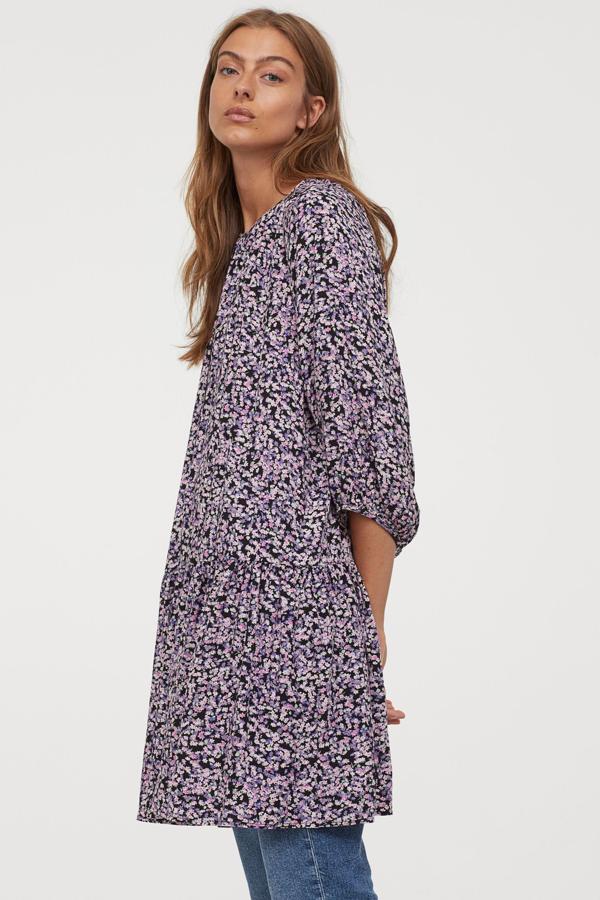 Diseño evasé corto con cuello redondo y mangas globo raglán tres cuartos para este vestido de fondo negro con estampado de flores en color lila que tiene costura fruncida en el bajo para dar volumen. De 19,99 euros ha pasado a costar 9,99 euros y está disponible entre las tallas XS y XXL.