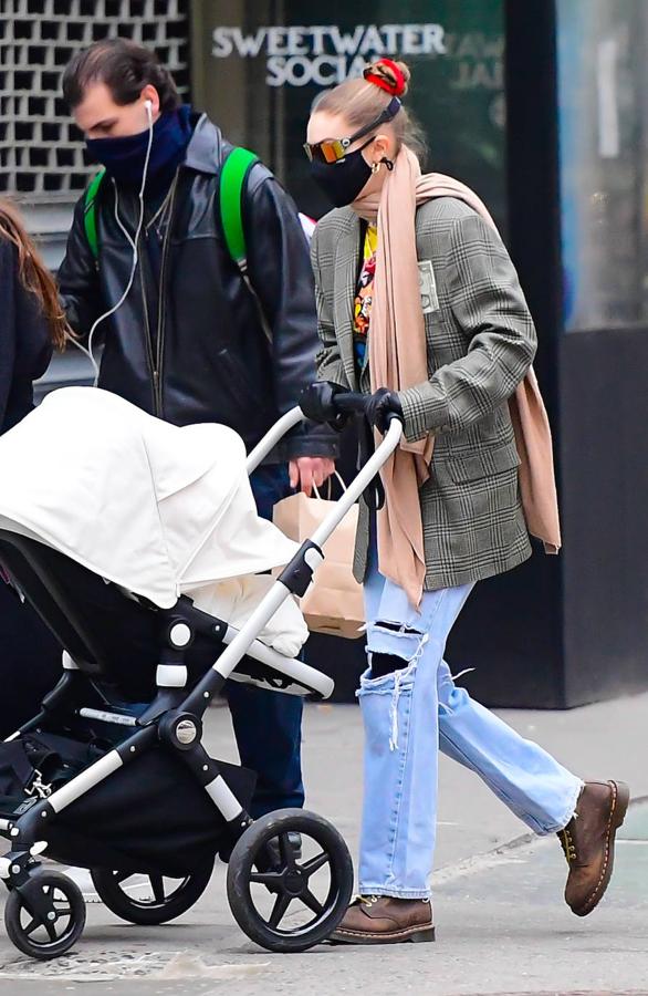 Con una americana masculina de hombreras XL y estampado de cuadros combinado con un par de vaqueros anchos con rotos y botas de cuero de estilo montañero.