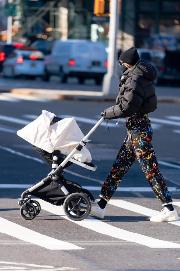 Con un par de vaqueros negros estampados de talle muy alto y un anorak corto con capucha.