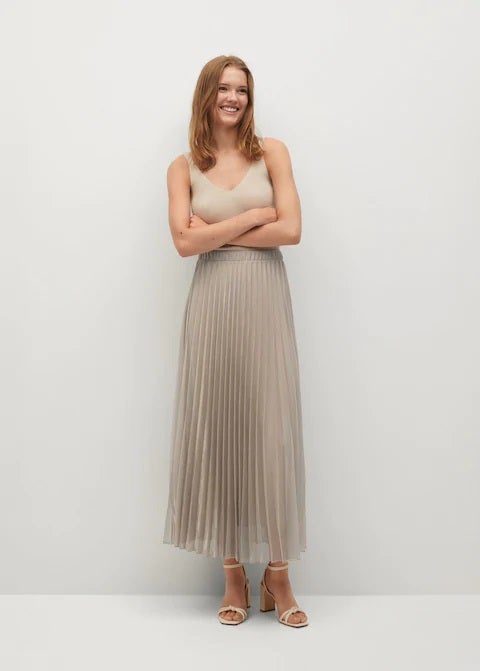 Eleva el nivel de tus estilismos de invierno y primavera con esta falda plisada en color beige con tejido metalizado y diseño acampanado. Encuéntrala en la nueva temporada de Mango. (49,99 euros).