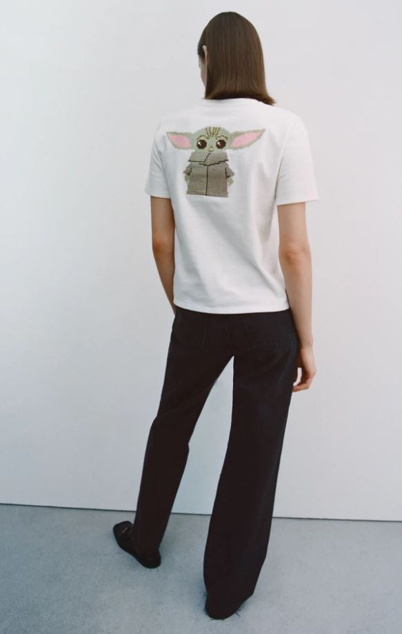 Esta camiseta para fans de The Madalorian', con Baby Yoda bordado a punto de cruz en la espalda y en un bolsillo delatero (15.95 euros).