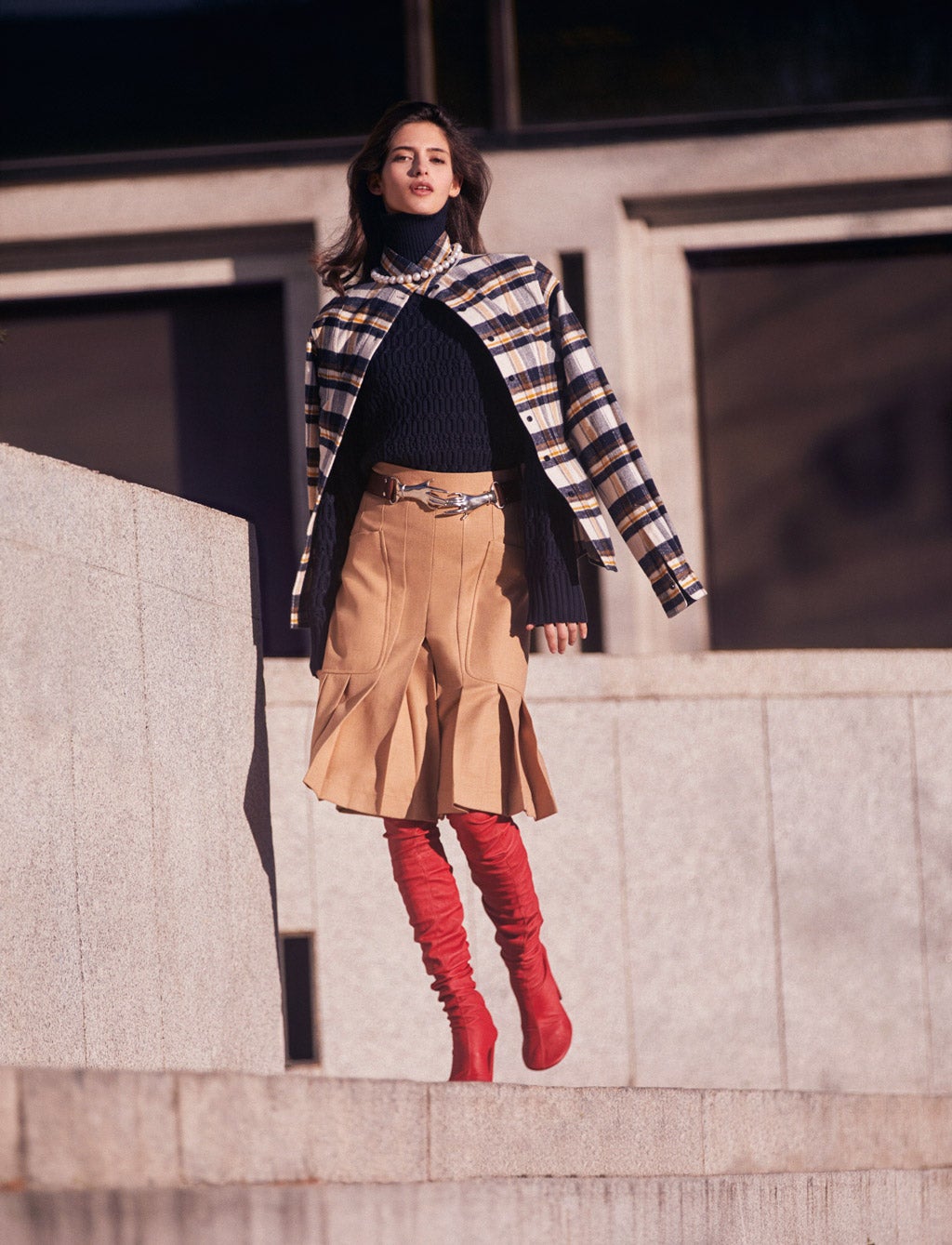 Sobrecamisa de franela, jersey, falda, botas de piel y cinturón, todo de Victoria Beckham. El collar de perlas es de Suarez.
