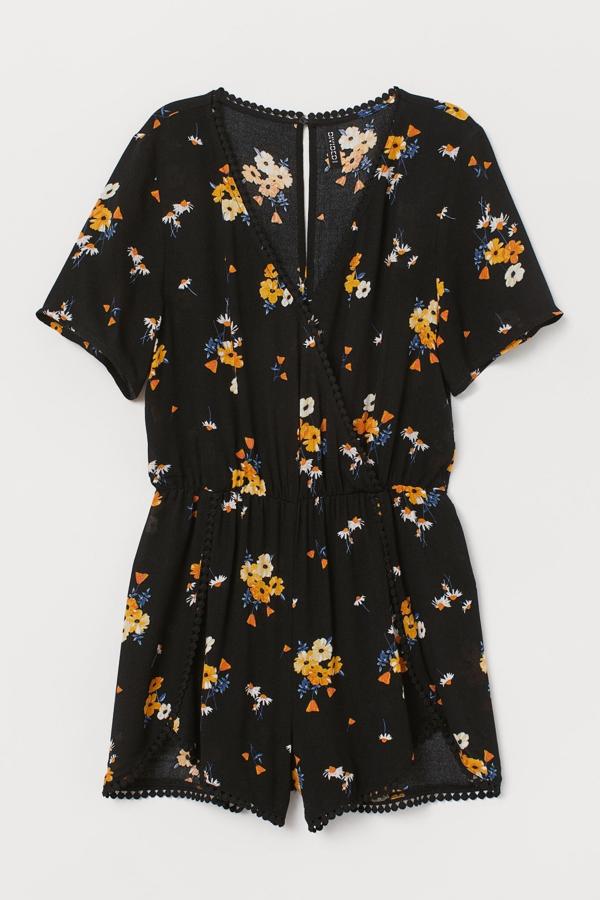 Con escote de pico y botón a presión oculto en la nuca, este mono corto en tejido arrugado de color negro con estampado floral tiene un precio de 24,99 euros.