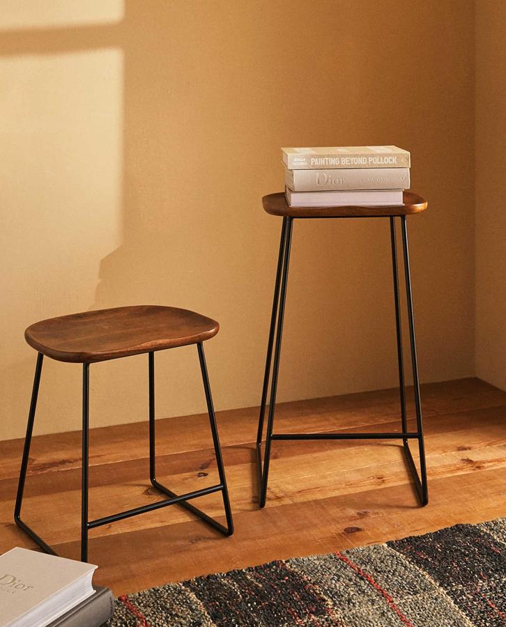 Fabricado en madera de mango con patas de metal, este taburete pequeño con asiento curvado tiene ahora un precio de 19,99 euros.
