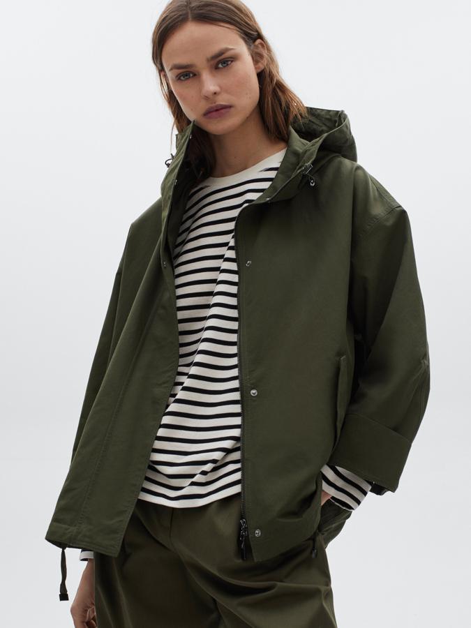 En color caqui, confeccionada en algodón con materiales repelentes al agua, esta parka corta de corte casual con cuello alto y capucha viene con dos bolsillos laterales de solapa, cierre de cremallera oculta por tapeta y bajo ajustable con cordones. Cuesta 99,95 euros y estará disponible entre las tallas XS y L.
