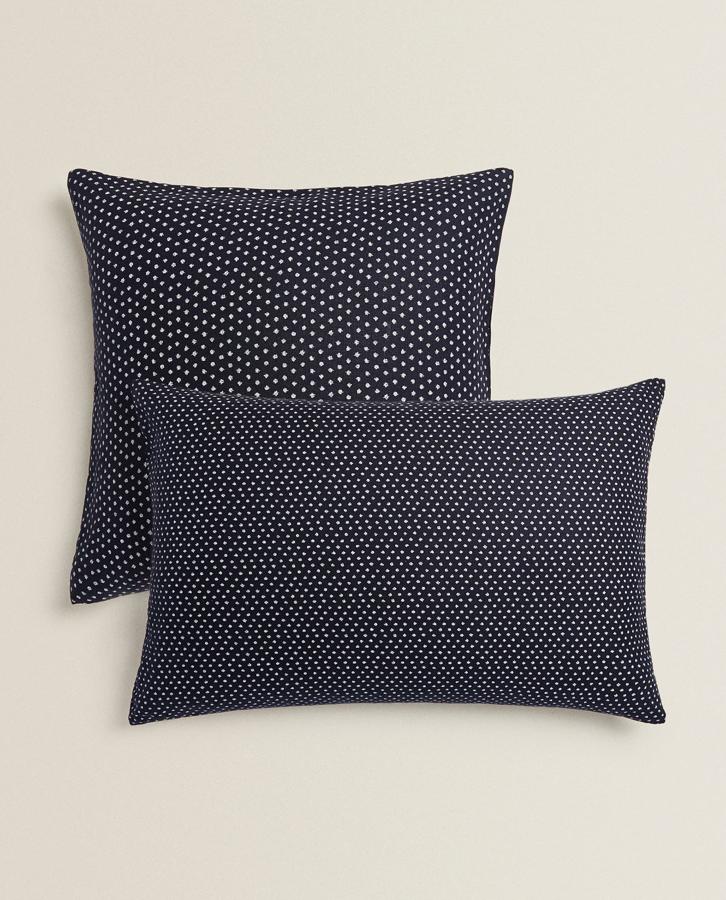 En color azul marino con pequeños lunares blancos, esta funda de cojín de lino está disponible en dos tamaños, 60x60 centímetros y 70x90 centímetros, y tiene un precio rebajado de 15,99 euros.