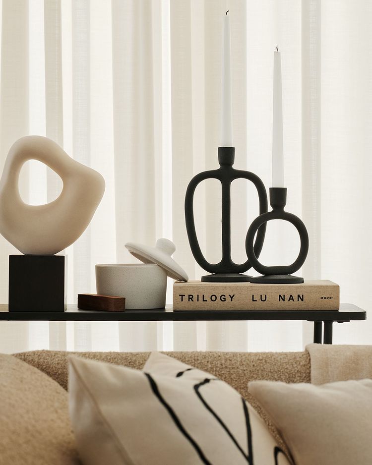 Decorar nuestro hogar con piezas que son auténticas obras de arte no es caro: en H&M Home, esta escultura cuesta 27.99 euros; los candelabros, desde 9.99 euros; y el cojín bordado, 4.99 euros.