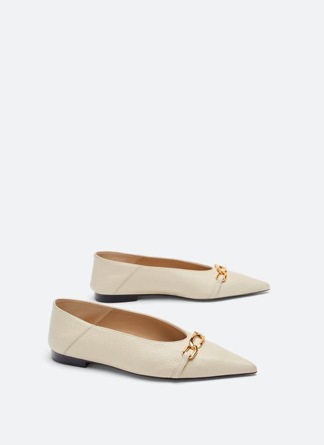 Estas bailarinas en piel crema con detalle de cadena se pueden llevar también destalonadas. Cuestan 39.90 euros en las rebajas de Uterqüe.