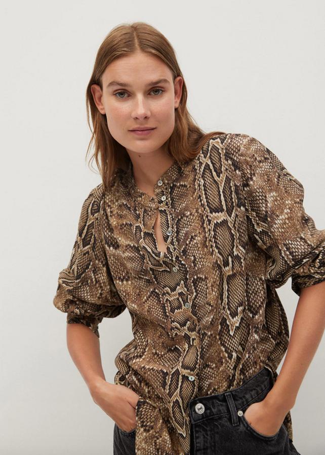 Esta camisa con estampado de serpiente de Mango está confeccionada en tejido fluido y es de diseño ancho. Con cuello redondo y mangas largas con puños abotonados, tiene cierre frontal de botones y de 29,99 euros ha pasado a 17,99 euros. Solo queda en las tallas XS, S y M.