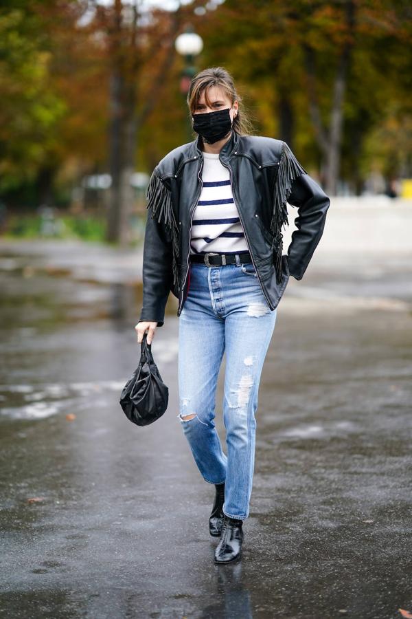 Cazadora motera de piel con camiseta de rayas marineras y vaqueros rotos.