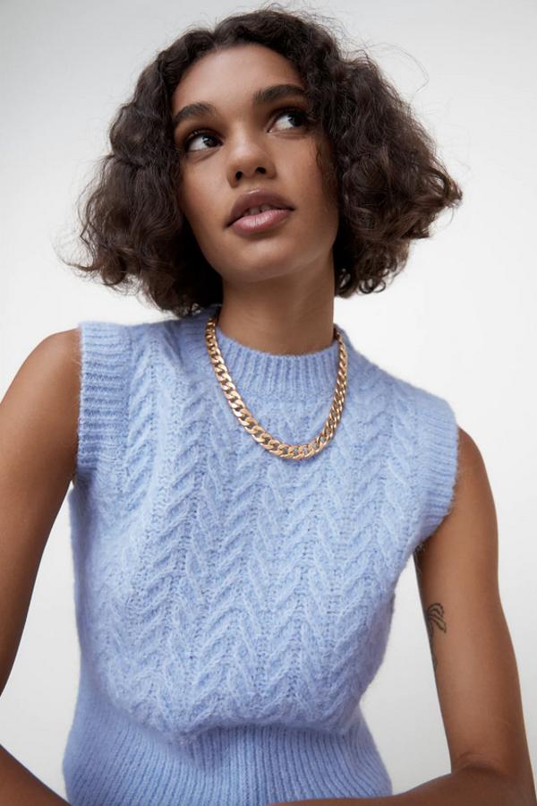 Diseño trenzado para este chaleco de Zara con cuello redondo y terminaciones en canalé. Disponible en azul claro, fucsia y verde con azul cuesta 19,95 euros y podemos encontrarlo en las tallas S, M y L.