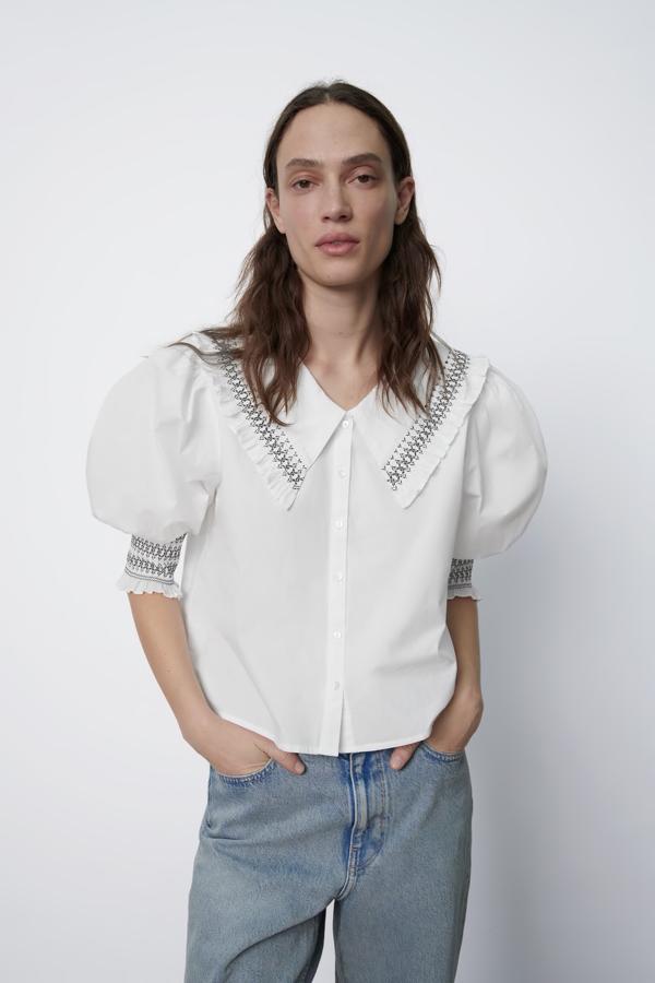 Blusa de popelín con manga corta abullonada y detalles de nido de abeja en las solapas y las mangas, de Zara (22,95 €).